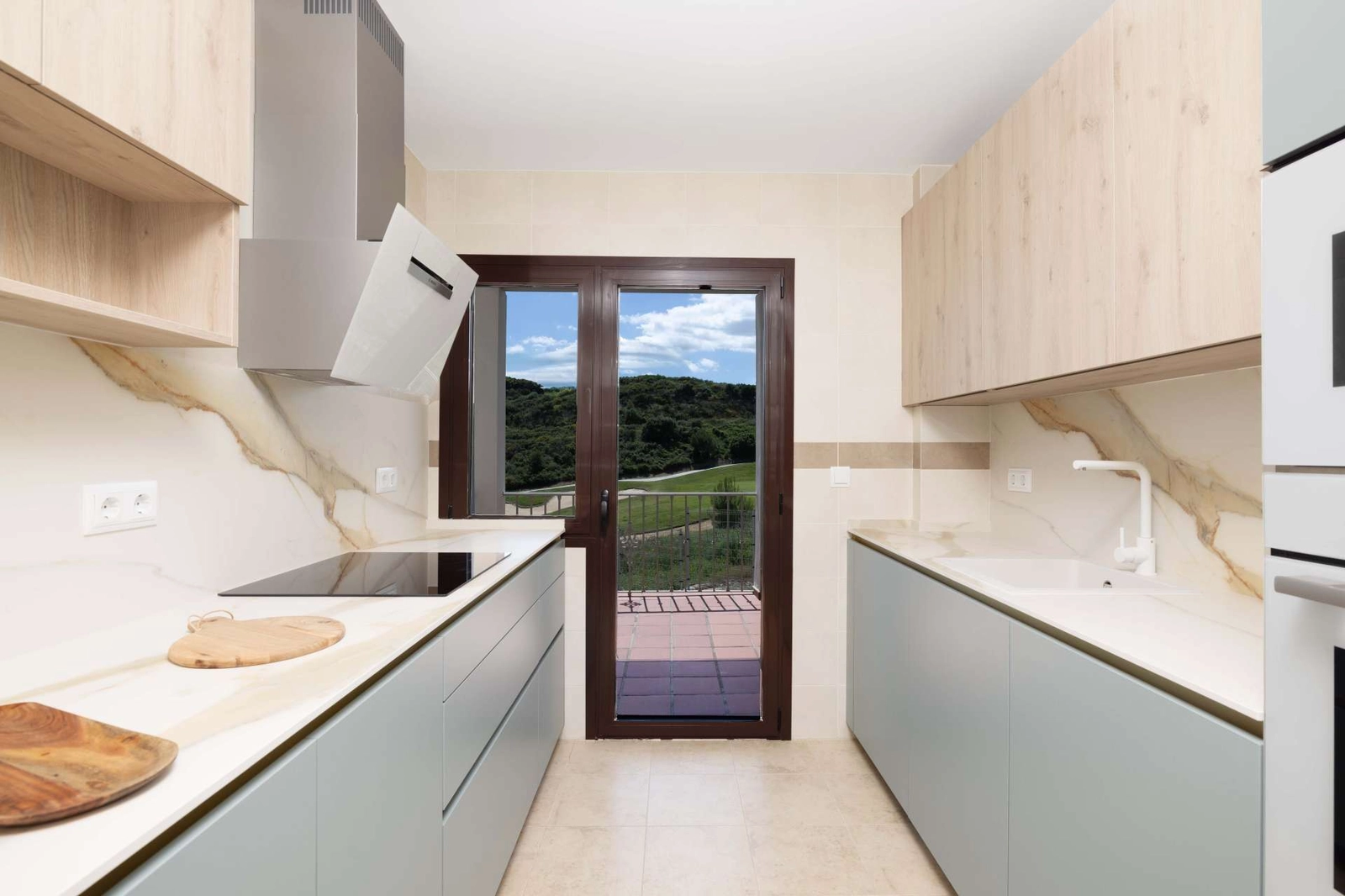 De moderne keuken is ontworpen voor functionaliteit en stijl, met uitzicht naar buiten.