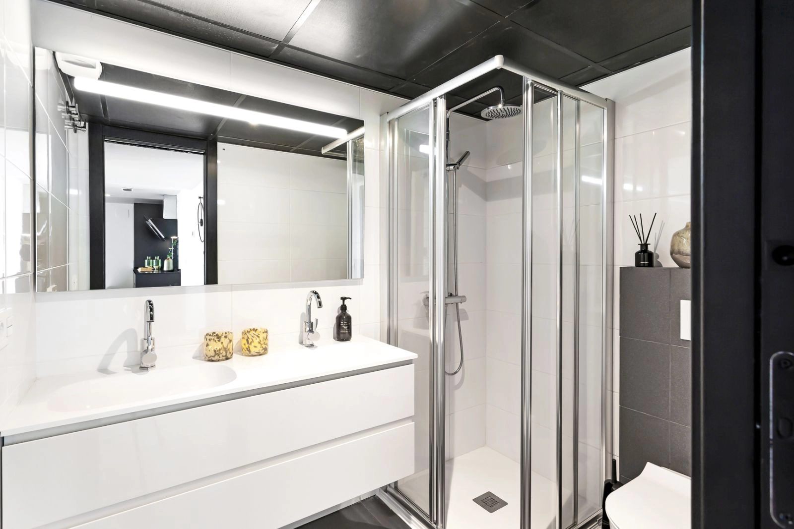 Een stijlvolle en functionele badkamer met moderne armaturen, een inloopdouche en hoogwaardige afwerkingen.