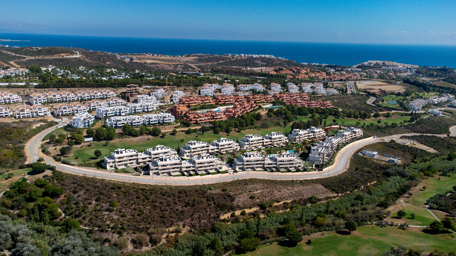 Een luchtfoto van het project, perfect geïntegreerd in het groene landschap van de Casares golfbaan, met de Middellandse Zee op de achtergrond.