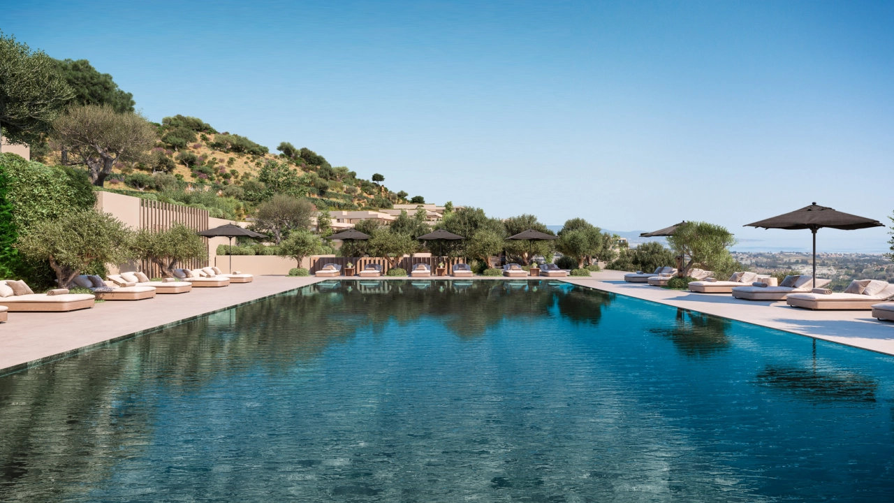 Het uitgestrekte gemeenschappelijke zwembad, omringd door weelderige tuinen en comfortabele ligstoelen.