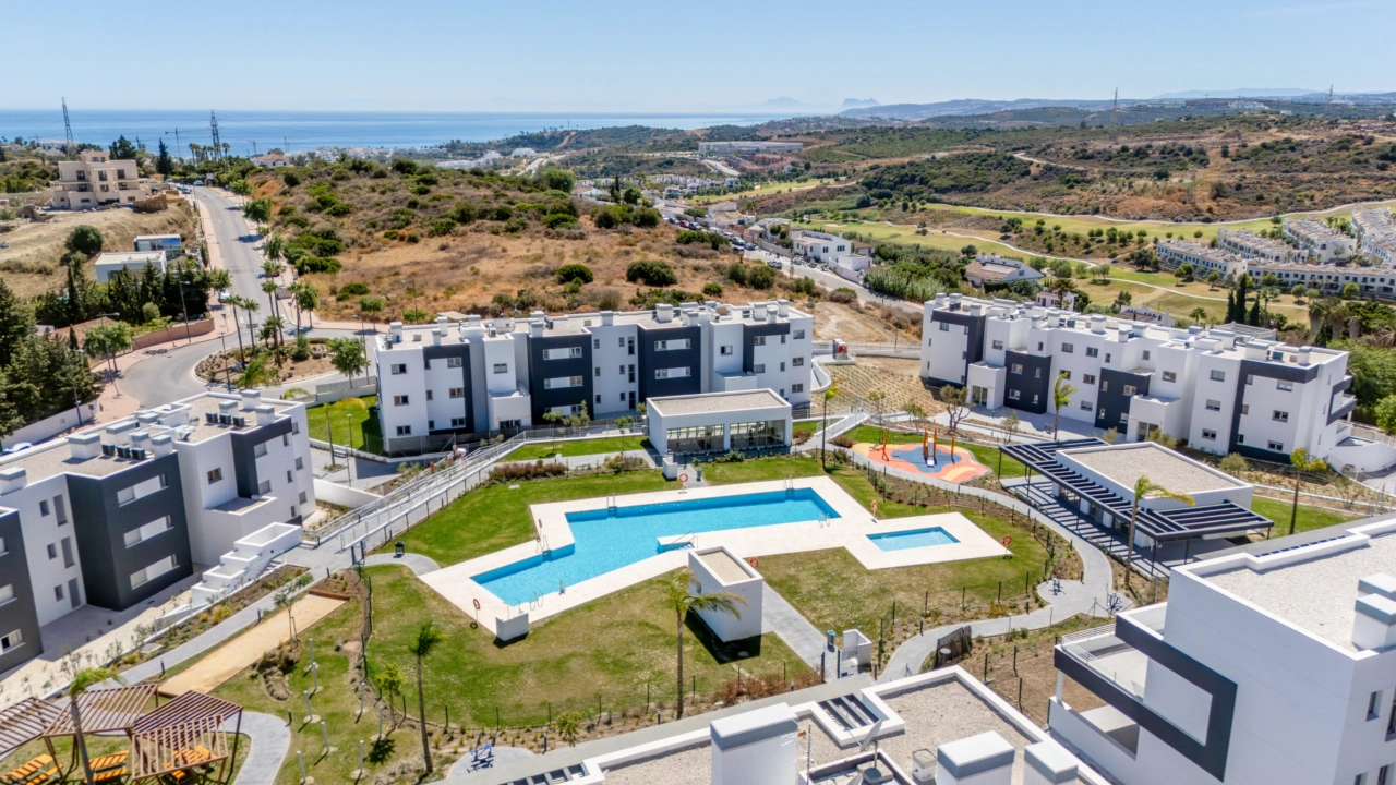Een prachtig perspectief van het voltooide complex, met de zwembaden en groene zones en de zee aan de horizon.