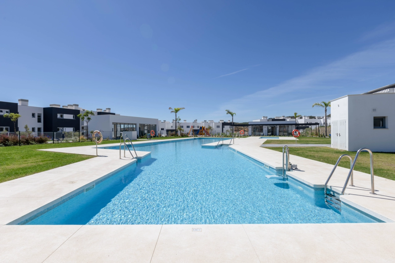 Het uitnodigende zwembad ligt te midden van prachtig aangelegde tuinen waar bewoners van kunnen genieten.