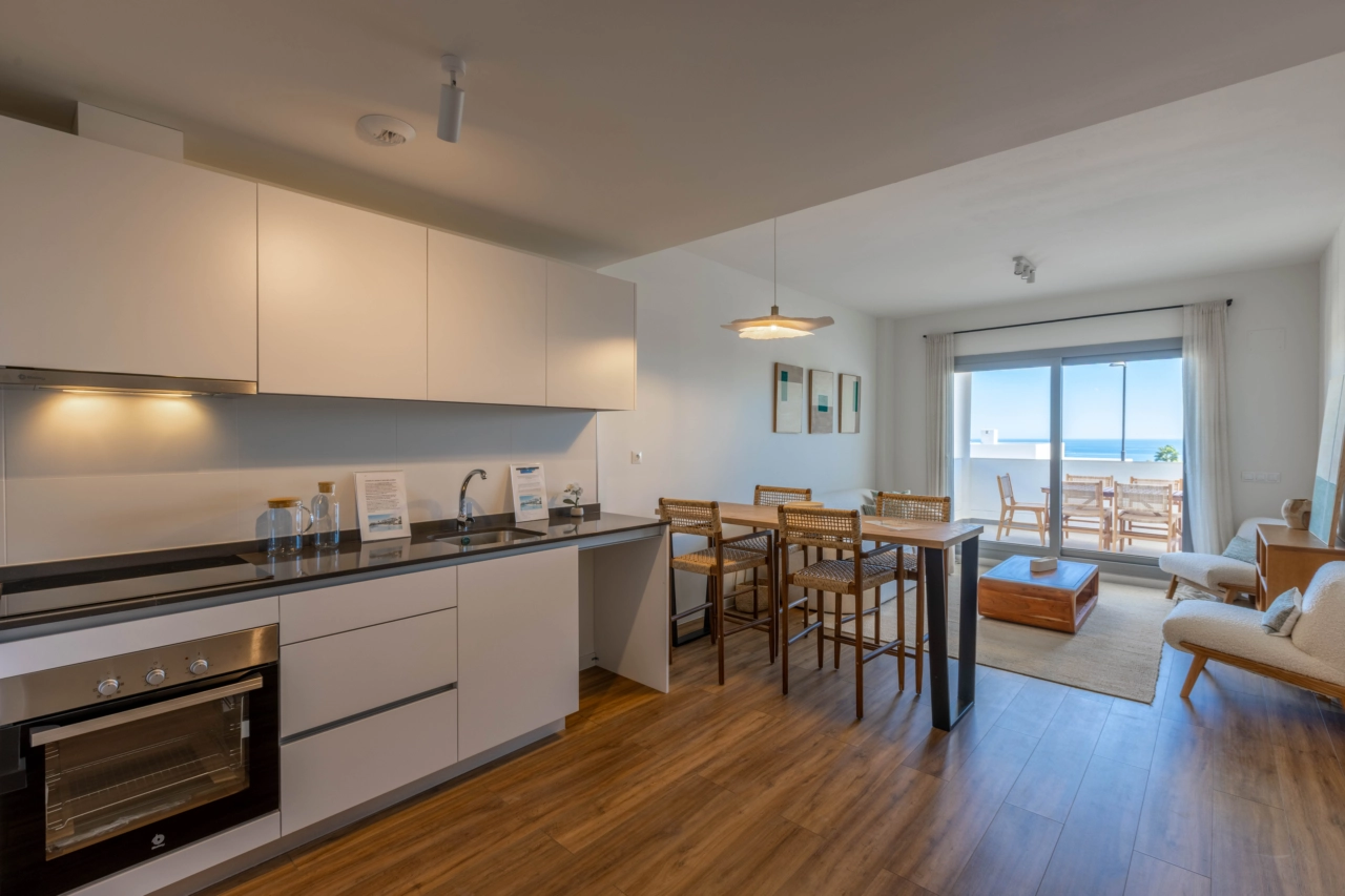 Een moderne, volledig uitgeruste keuken die uitkomt op de woonkamer, waardoor een licht en gezellig hart van de woning ontstaat.