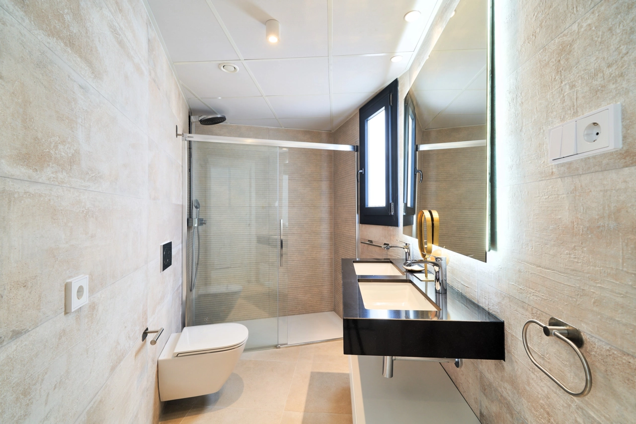 Elegant badkamerontwerp met hoogwaardige materialen, een ruime douche en moderne voorzieningen.