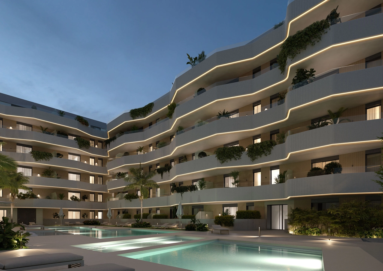 Het gemeenschappelijke zwembad en de tuinen 's nachts prachtig verlicht, wat een magische sfeer creëert.