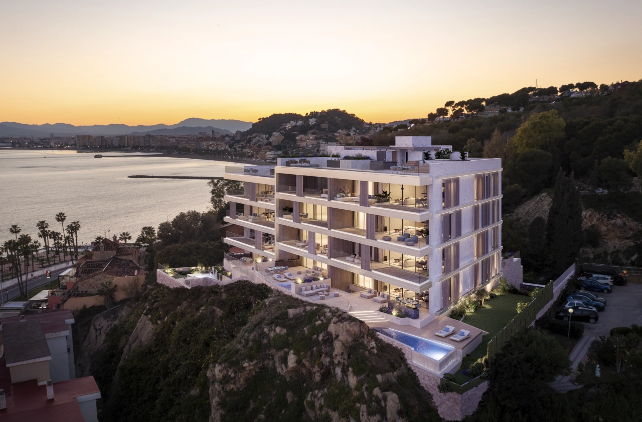 De moderne architectuur van het complex is prachtig verlicht in de schemering, met uitzicht op de kustlijn van Malaga.