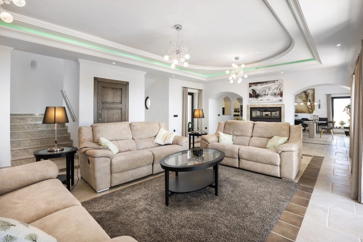 De elegante en ruime woonkamer, gevuld met natuurlijk licht, is ontworpen voor comfort en ontspanning.