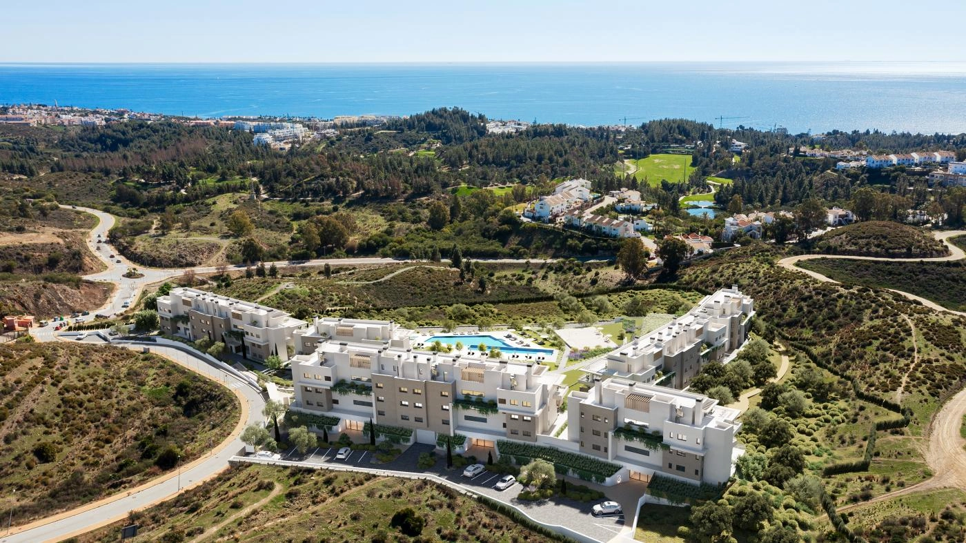 Een luchtfoto van het project, perfect geïntegreerd in het groene landschap van Mijas Costa, met de Middellandse Zee aan de horizon.