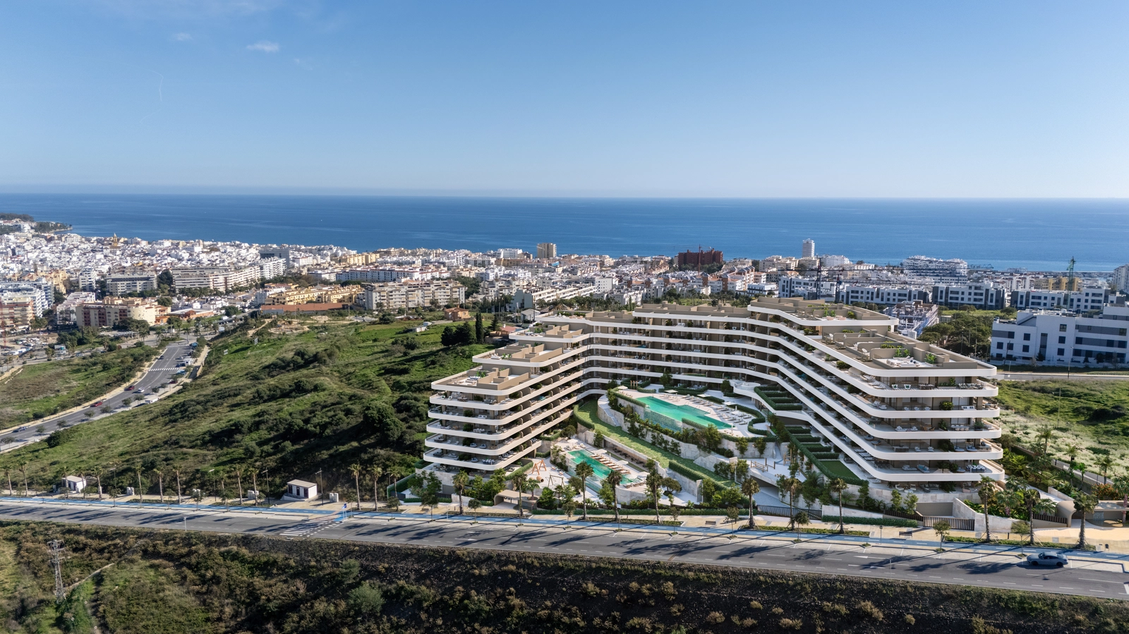 Een luchtfoto van het complex, met zijn unieke architectuur en bevoorrechte ligging met uitzicht op de zee en Estepona.
