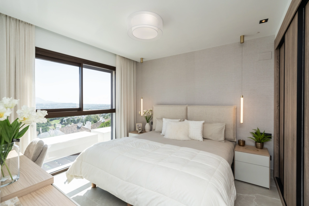 De hoofdslaapkamer is een rustgevend toevluchtsoord met grote ramen die het prachtige landschap omkaderen.