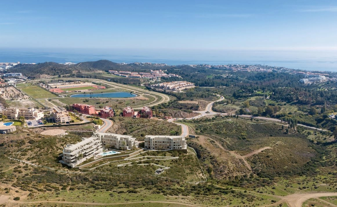 Een luchtfoto die de toplocatie van de ontwikkeling in Mijas toont, dicht bij de zee en lokale voorzieningen.