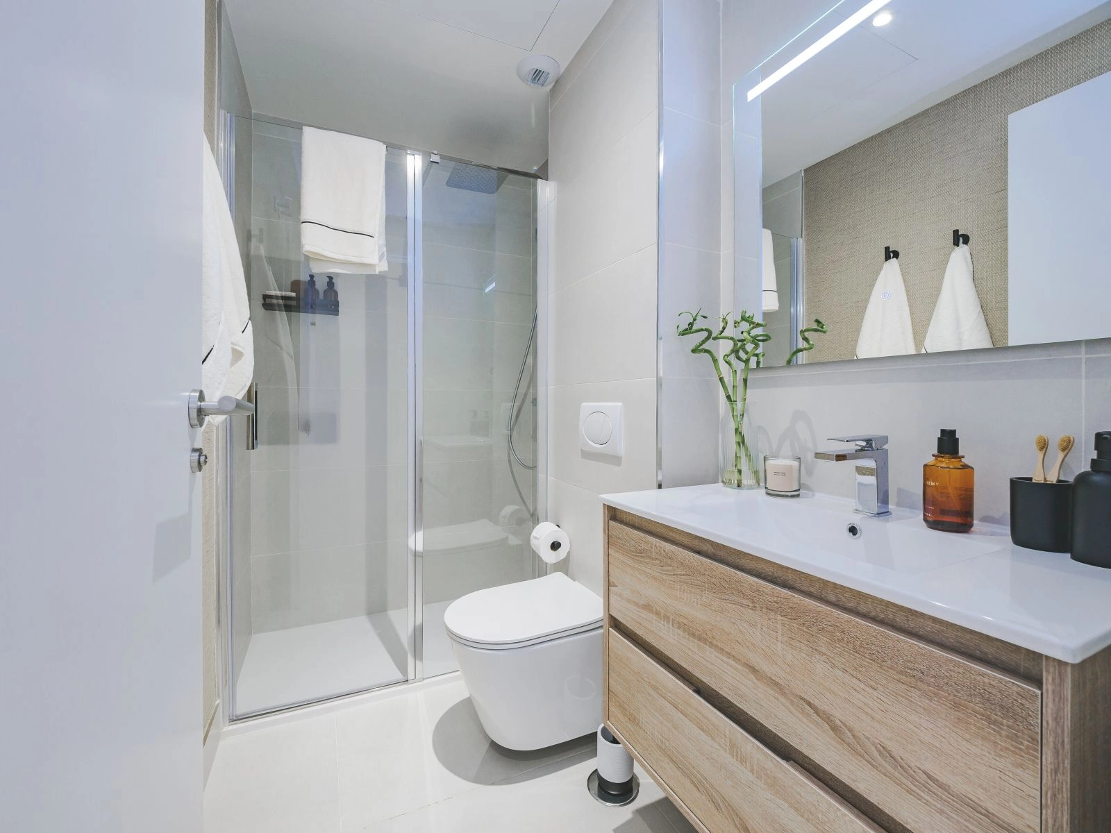 Een tweede badkamer die moderne stijl en functionaliteit toont met een ruime inloopdouche.