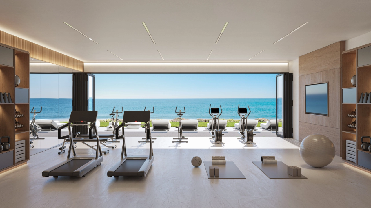 Het ultramoderne fitnesscentrum biedt een inspirerende ruimte om uw wellnessroutine te onderhouden, compleet met uitzicht op zee.