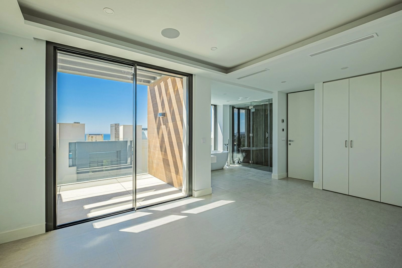 De master suite biedt een sereen en ruim toevluchtsoord met directe toegang tot een privé terras.