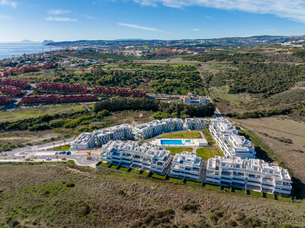 Het centrale zwembad en de ligweide, omgeven door aangelegde tuinen, creëren een privé-oase voor bewoners.