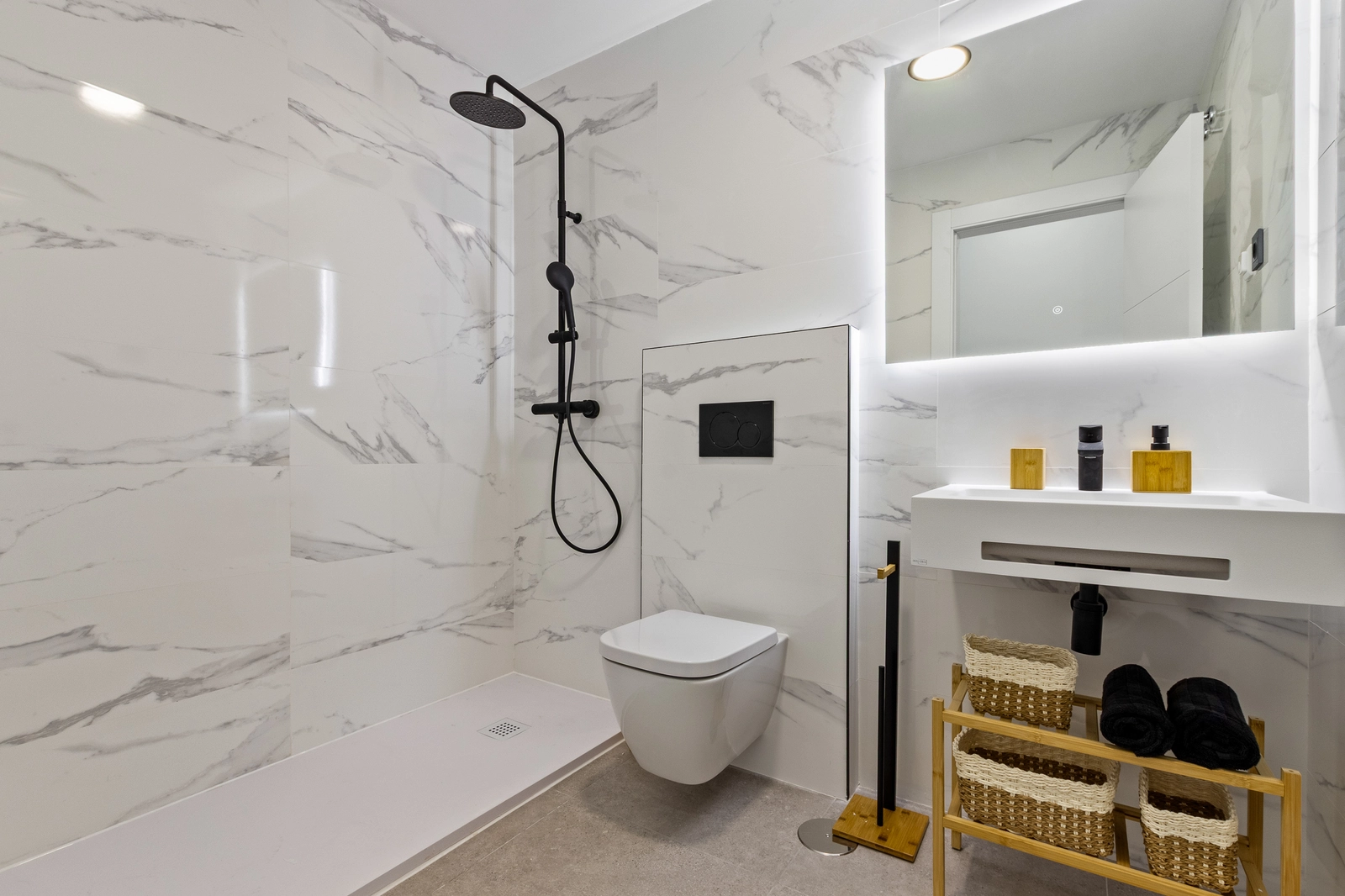 Een eigentijdse badkamer afgewerkt met hoogwaardige materialen, voorzien van een inloopdouche en modern sanitair.