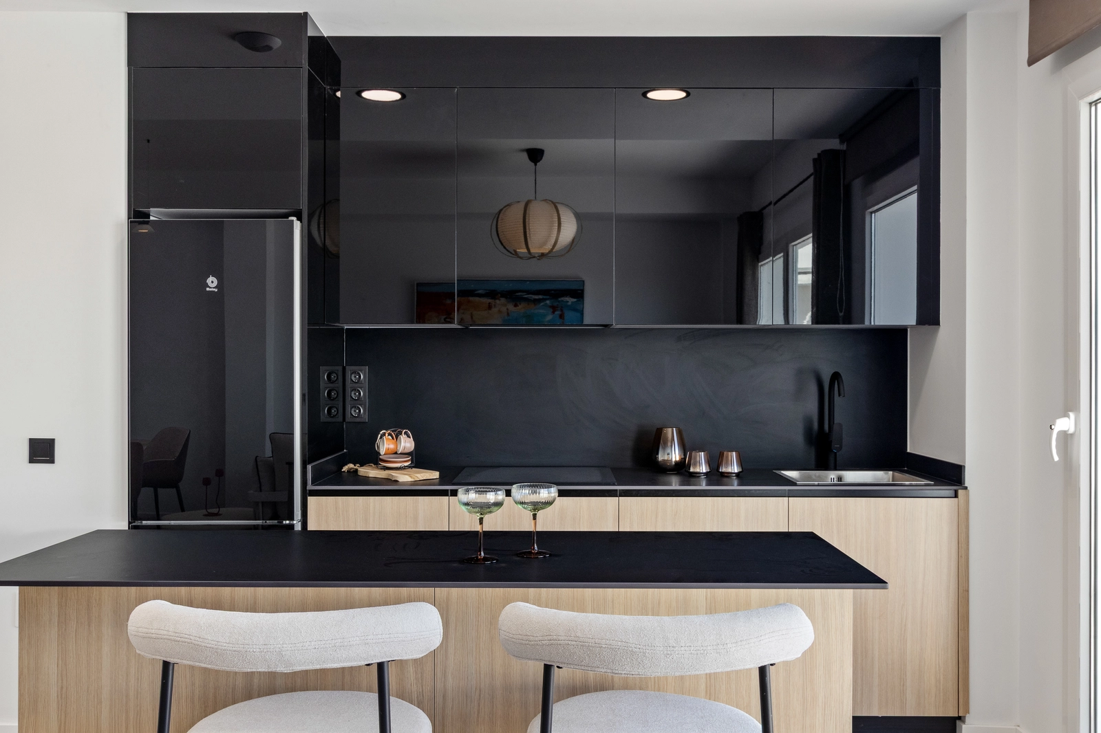 De strakke, moderne keuken is volledig uitgerust met hoogwaardige apparatuur en beschikt over een praktische ontbijtbar.