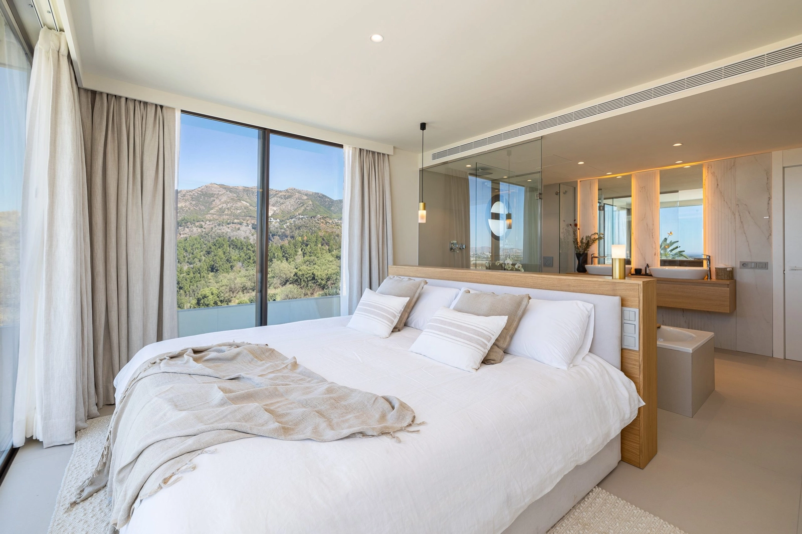 De hoofdslaapkamer is een vredig toevluchtsoord, met een open ensuite badkamer en grote ramen met serene uitzichten.